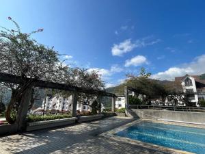 una piscina con pérgola junto a una casa en The Van Gogh Loft 梵高小栈 at Selesa Hillhomes en Bukit Tinggi