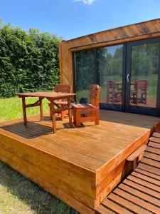 una terraza de madera con mesa de picnic y sillas en Obytný kontejner Cabin Stars, en Zátor