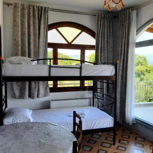 2 Etagenbetten in einem Zimmer mit Fenster in der Unterkunft Οδυσσέας in Stavros
