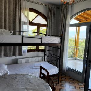 2 łóżka piętrowe w pokoju z oknem w obiekcie Οδυσσέας w Stavrós