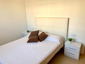 a bedroom with a large white bed with two pillows at TROPIKANA in Miami Platja