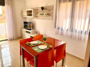 uma sala de jantar com uma mesa e cadeiras vermelhas em TROPIKANA em Miami Platja