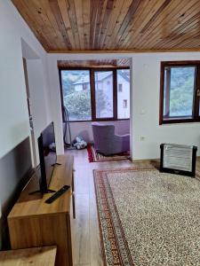 ein Wohnzimmer mit einem TV und einem Sofa in der Unterkunft Hamsiköy doğada dubleks konaklama in Macka