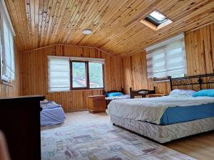 1 Schlafzimmer mit 2 Betten und Holzdecke in der Unterkunft Hamsiköy doğada dubleks konaklama in Macka
