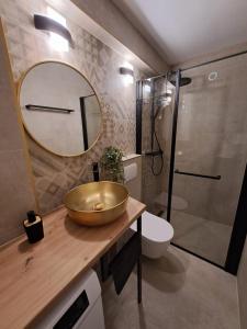 y baño con lavabo de oro y ducha. en Studio Apartments Leut & Lanterna en Vis