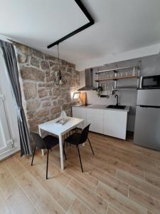 a kitchen and dining room with a white table and chairs at Studio Apartments Leut & Lanterna in Vis