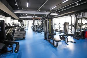 a gym with lots of treadmills and machines at Chagala Residence Atyrau in Atyrau