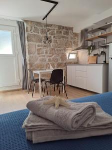 a room with a kitchen and a table with a bed at Studio Apartments Leut & Lanterna in Vis +22 photos