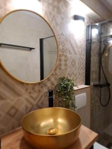 a bathroom with a gold sink and a mirror at Studio Apartments Leut & Lanterna in Vis