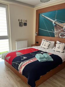 a bedroom with a large bed with towels on it at Gdańsk Venice AMB - Wyspa Sobieszewska in Gdańsk