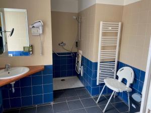 a bathroom with a sink and a shower with blue tiles at LOGIS HOTEL - La Petite Rade in Le Havre
