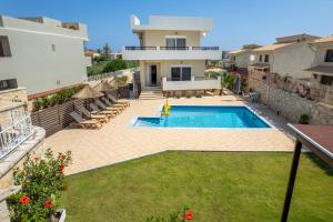 un patio trasero con piscina y una casa en Villa Sophia-Elpis en Hersonissos