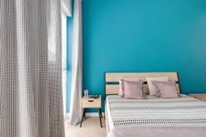 a blue bedroom with a bed and a blue wall at Apartamenty stadion narodowy in Warsaw