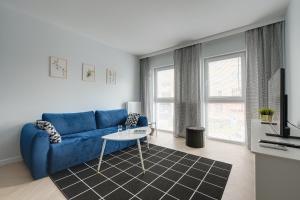 salon z niebieską kanapą i stołem w obiekcie Apartamenty Stadion Narodowy w Warszawie