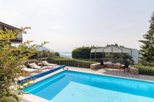 uma piscina com um gazebo ao lado de uma casa em Villa Montagne & Lago by Garda FeWo em Villanuova sul clisi