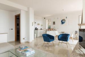 uma sala de estar com cadeiras azuis e uma mesa em Villa Montagne & Lago by Garda FeWo em Villanuova sul clisi
