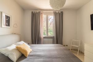 um quarto com uma cama e uma janela em Villa Montagne & Lago by Garda FeWo em Villanuova sul clisi