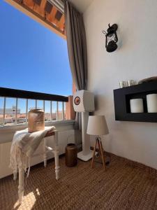 a room with a window and a table and a lamp at Charmant duplex vue mer et étangs ! Clim / Parking in Frontignan