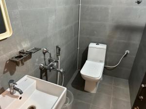 ein Badezimmer mit einem weißen WC und einem Waschbecken in der Unterkunft KKM Highlands in Kurnool