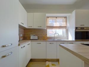 una cocina blanca con armarios blancos y fregadero en 21 Townhouse in St Julians, en Paceville