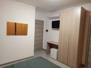 a room with a closet and a desk and a television at D'Orazio mare e dintorni in Trapani