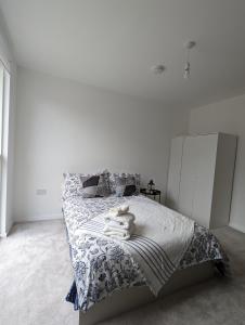 una camera da letto bianca con un letto e asciugamani di Kingwood apartaments a Londra