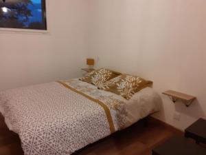 Habitación pequeña con cama y mesita de noche en Gîte la Chevêche en Treize-Vents