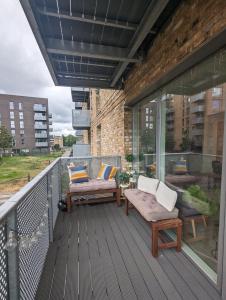 una terrazza con sedie e tavoli sul balcone di Kingwood apartaments a Londra