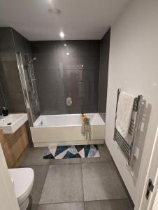 ein Badezimmer mit einer Badewanne, einem WC und einem Waschbecken in der Unterkunft Kingwood apartaments in London
