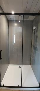 a shower with a glass door in a bathroom at Wisteria Barn, Trewethen, St Teath, nr Port Isaac in Saint Teath