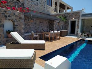 a villa with a swimming pool and a patio at Villa Kairos- Aegean Sea in Masouri