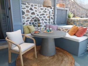 a table and chairs on a patio with a table and a couch at Villa Kairos- Aegean Sea in Masouri