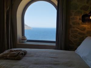 a bedroom with a window looking out at the ocean at Villa Kairos- Aegean Sea in Masouri