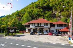 un edificio con auto parcheggiate in un parcheggio di Motel Konak a Sarajevo