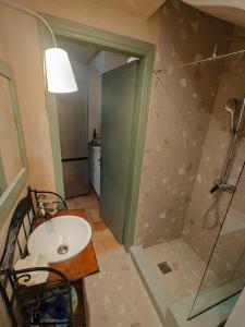uma casa de banho com um lavatório e um chuveiro em Diamond by the Sea em Melíssion