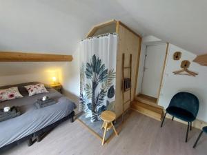 ein Schlafzimmer mit einem Bett und einem Stuhl in der Unterkunft Au Bonheur Fait Maison in Saint-Maurice-sur-Moselle