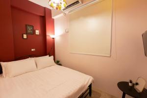 竹山鎮的住宿－林厝邊 ，卧室配有白色的床和红色的墙壁