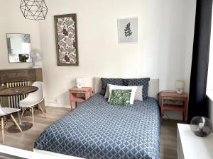 a bedroom with a bed and a table and chairs at Élégant studio rénové in Boulogne-sur-Mer