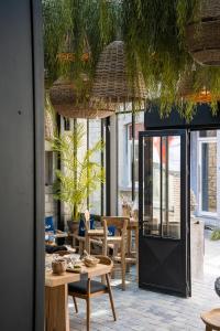 uma sala de jantar com mesa, cadeiras e janelas em Hotel LEA - Maison Caerdinael em Durbuy