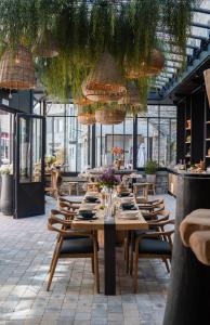een eetkamer met een tafel en stoelen en planten bij Hotel LEA - Maison Caerdinael in Durbuy