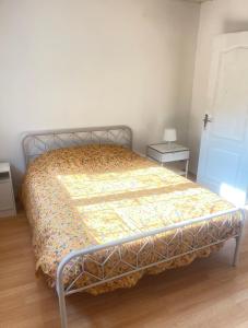 een bed met een dekbed in een slaapkamer bij Les milles feuilles in Marseille