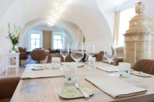 una mesa de madera con copas de vino encima en Am Pfarrhof - Gourmethotel by Harald Irka en Sankt Andrä-Höch