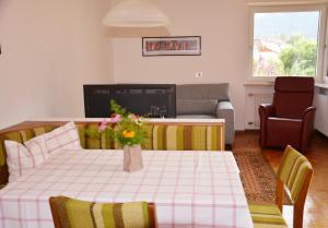 a living room with a table with a vase of flowers on it at Apartment Turmblick in Sarntal