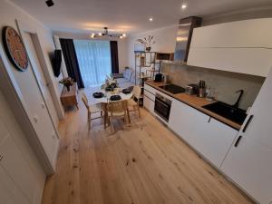 Ķesterciems的住宿－Angren Albatross, SEA & SPA，厨房以及带桌椅的起居室。