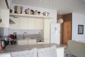 cocina con armarios blancos y nevera blanca en Ilian Studios, en Parga