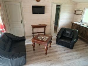 a living room with a table and chairs and a television at Rasos kiemelis in Palanga