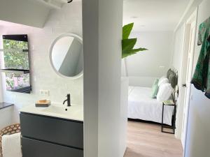 a bathroom with a sink and a bed with a mirror at Suite Spot Houten in Houten