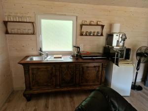 a kitchen with a sink and a window and a refrigerator at Rasos kiemelis in Palanga