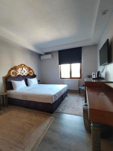 a bedroom with a large bed and a desk at Gala Otel Edirne in Edirne