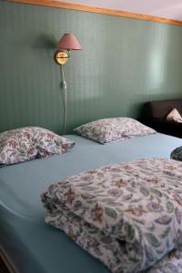 a bedroom with a bed with two pillows and a lamp at Mauranger Kro & Gjestehus in Bondhus